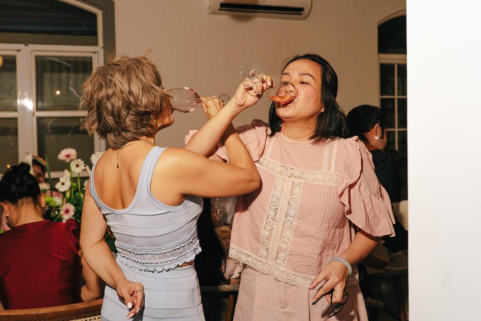 Two guests linking arms for a celebratory drink