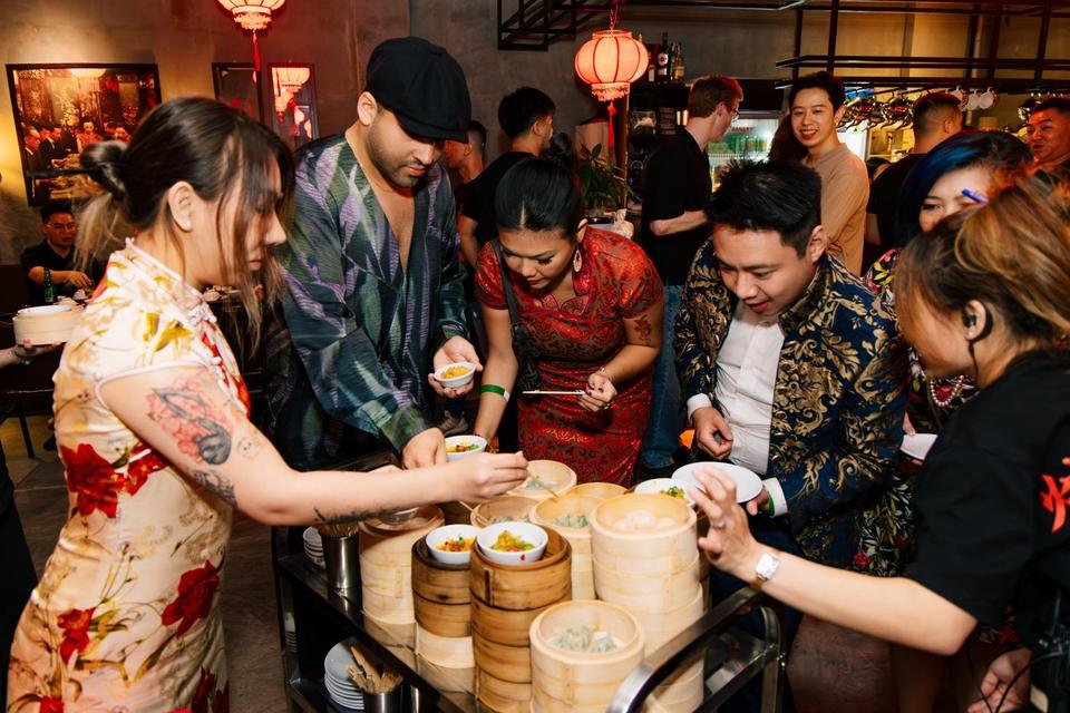 Guests crowding round a dim sum trolley of bamboo steamers
