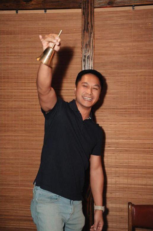 A guest ringing the gặp bell with a huge grin