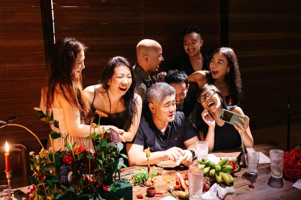 Guests crowding round a phone, laughing together