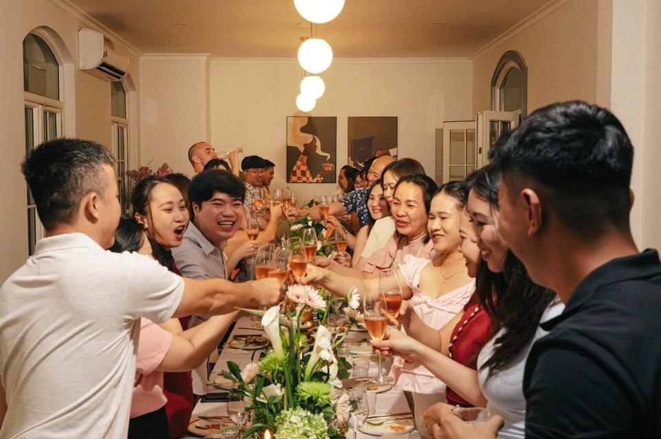Guests on their feet clinking glasses down a long table